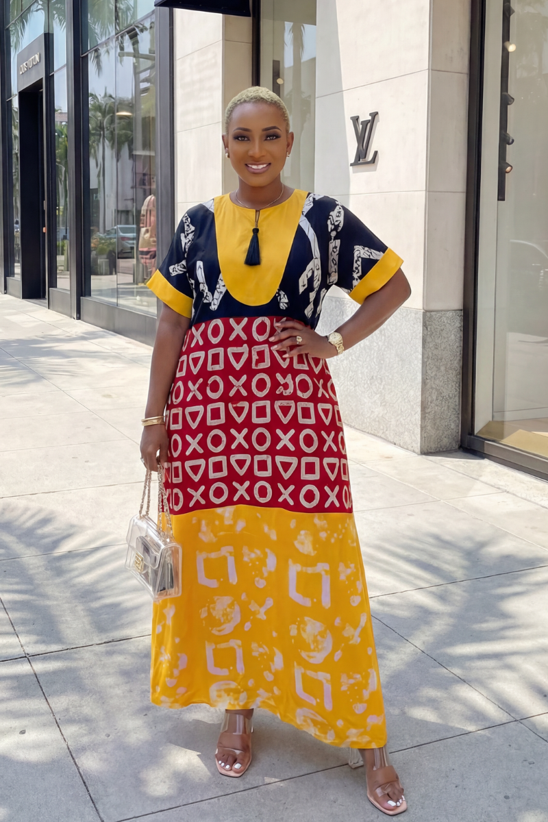 Woman wearing a colorful dress with geometric patterns in an urban setting.