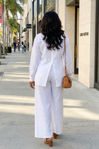Woman in a white outfit walking on a city street