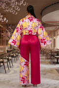 Woman wearing a colorful kimono with floral patterns in a restaurant setting