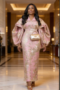 Woman in a pink and gold outfit with a matching handbag in an elegant interior setting.