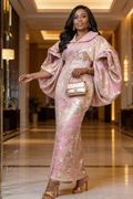 Woman in a pink and gold dress holding a handbag in an elegant interior setting