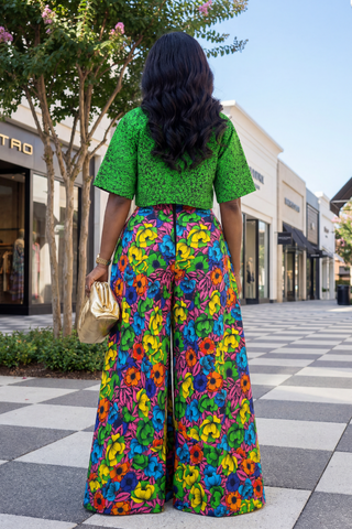 Person wearing a green top and colorful floral pants in an outdoor setting.