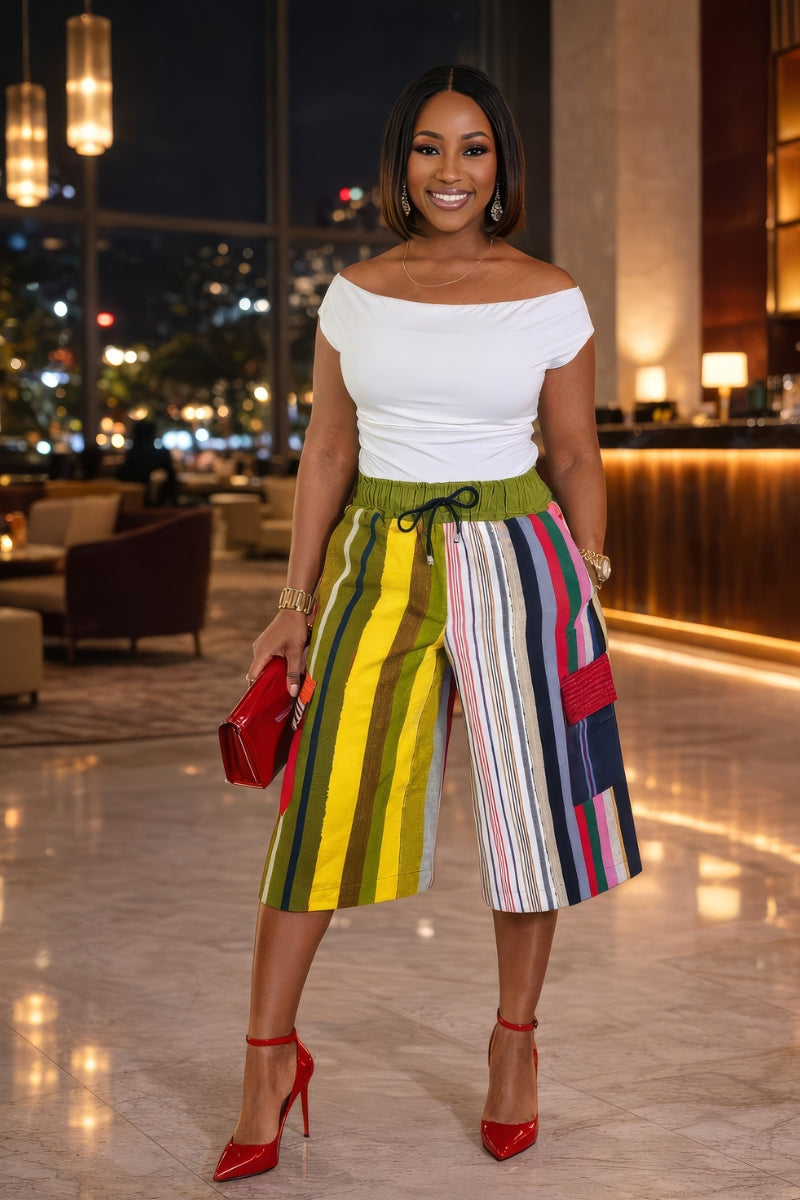 Woman in a stylish outfit with a colorful aso-oke shorts in an indoor setting.