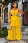 Woman in a yellow lace dress standing on a city street.