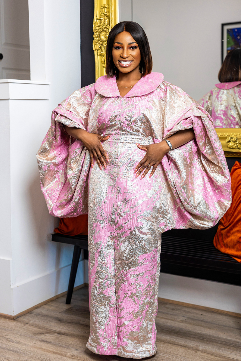 Woman wearing a pink and gold traditional outfit standing in front of a mirror.