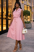 Woman in a pink dress standing in front of a Dior store.