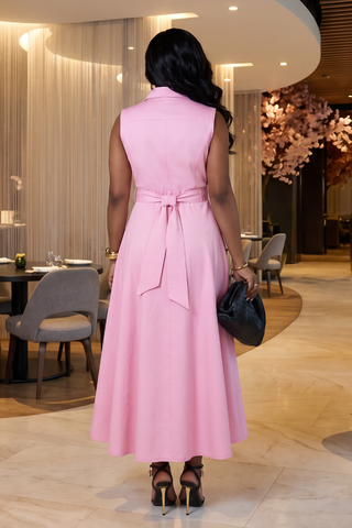 Woman in a pink dress standing in an elegant indoor setting.