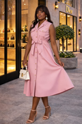 Woman in a pink dress standing in front of a Dior store.