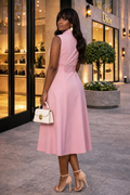 Woman in a pink dress standing in front of a Dior store.