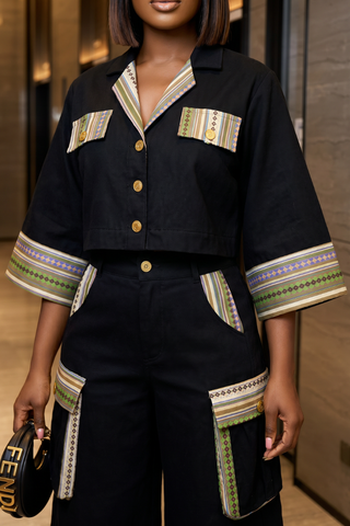 Person wearing a black outfit with colorful patterns, holding a Fendi handbag.