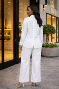 Woman in a white outfit standing outside a Dior store.