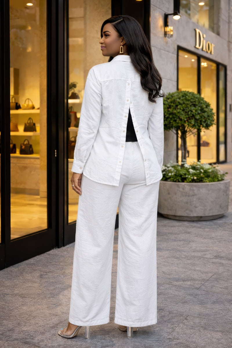 Woman in a white outfit standing outside a Dior store.