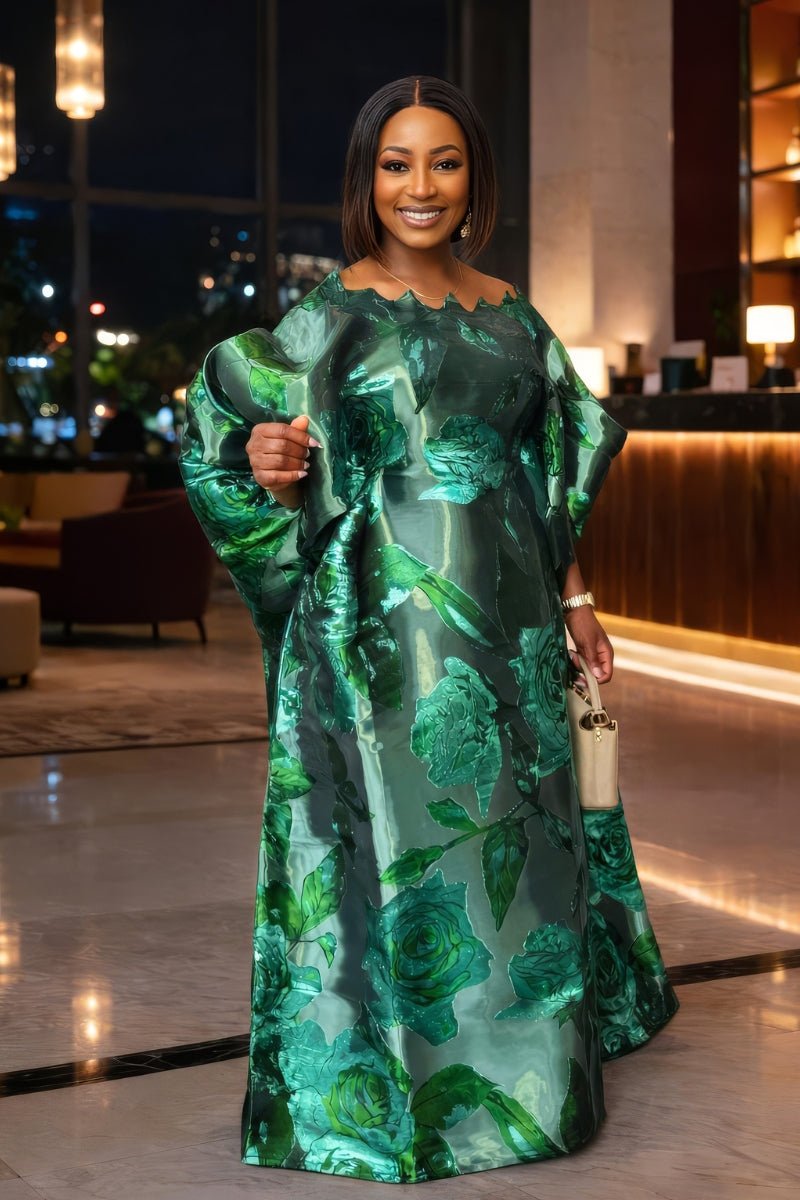 Woman in a green floral dress standing indoors with blurred background
