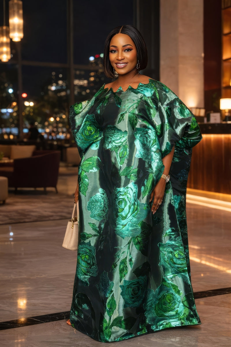 Woman in a green floral dress standing in an indoor setting with blurred background