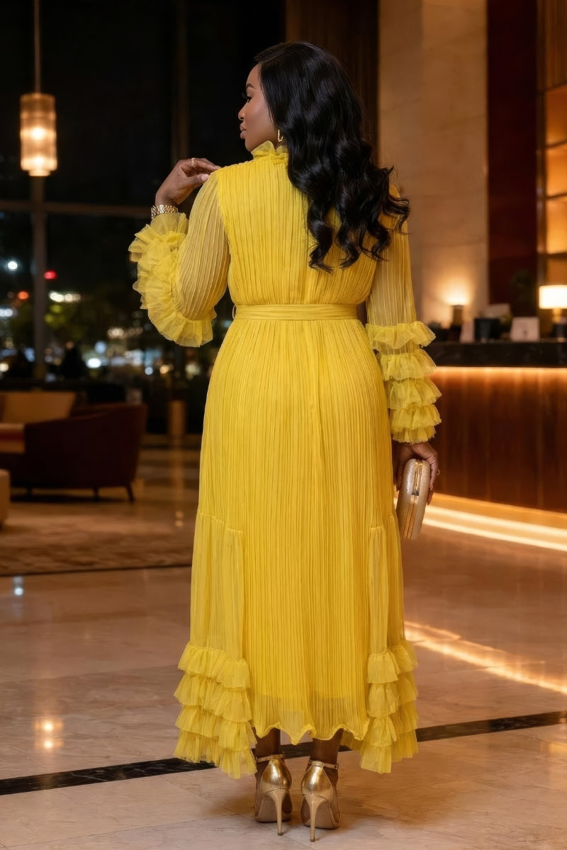 Woman in a yellow dress standing in an elegant indoor setting