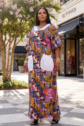 Woman in a colorful patterned dress standing in front of a store with floral decorations.