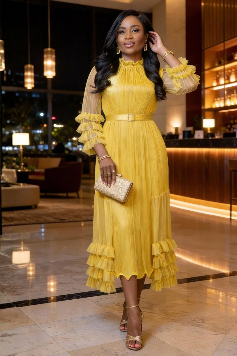 Woman in a yellow dress standing in an elegant indoor setting
