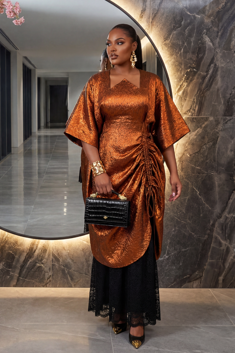 Woman in an orange and black dress holding a black handbag in a hallway.