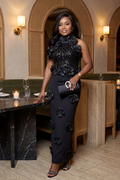 Woman in a black floral dress standing in a restaurant setting