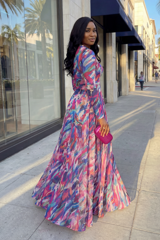 Woman in a colorful dress standing on a city street.