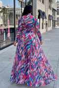 Woman wearing a colorful dress walking on a city street.