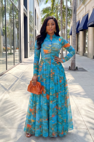 Woman in a blue floral dress standing on a city street.