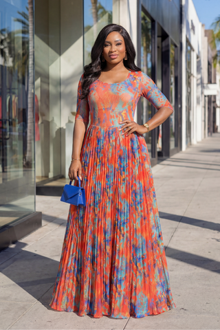 Woman in a colorful dress standing on a city street.