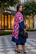 Woman wearing a colorful patterned shawl in front of an Etro store.