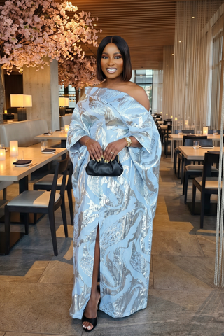 Woman in a blue off-shoulder dress with a black clutch in a restaurant setting