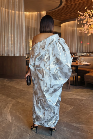 Woman in a patterned dress standing in a restaurant setting